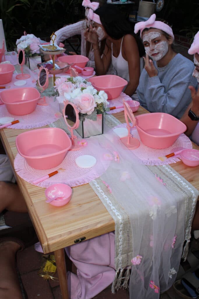 Guests seated around a spa party table outdoors.